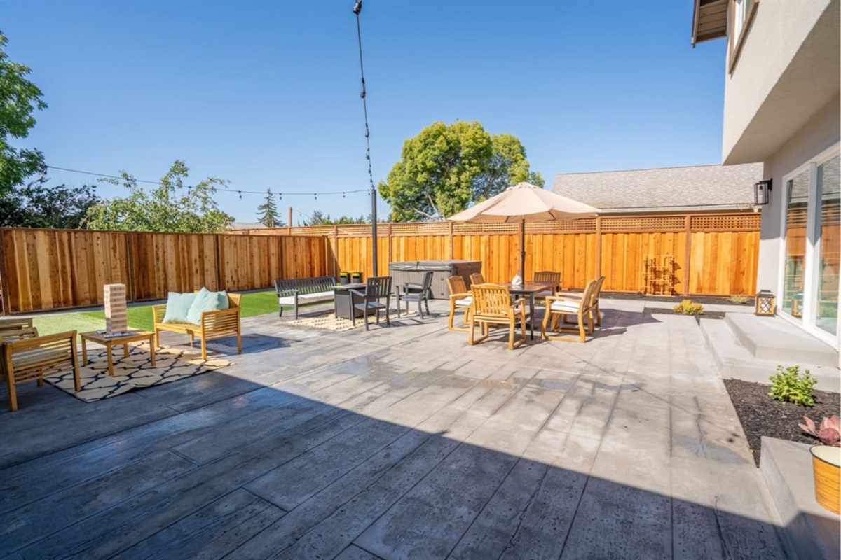 Backyard with hot tub, outdoor dining and seating with fire pit.