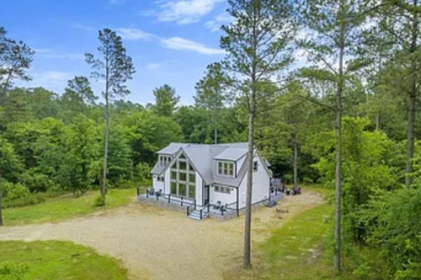 Scenic aerial view of the cabin surrounded by peaceful woodland.