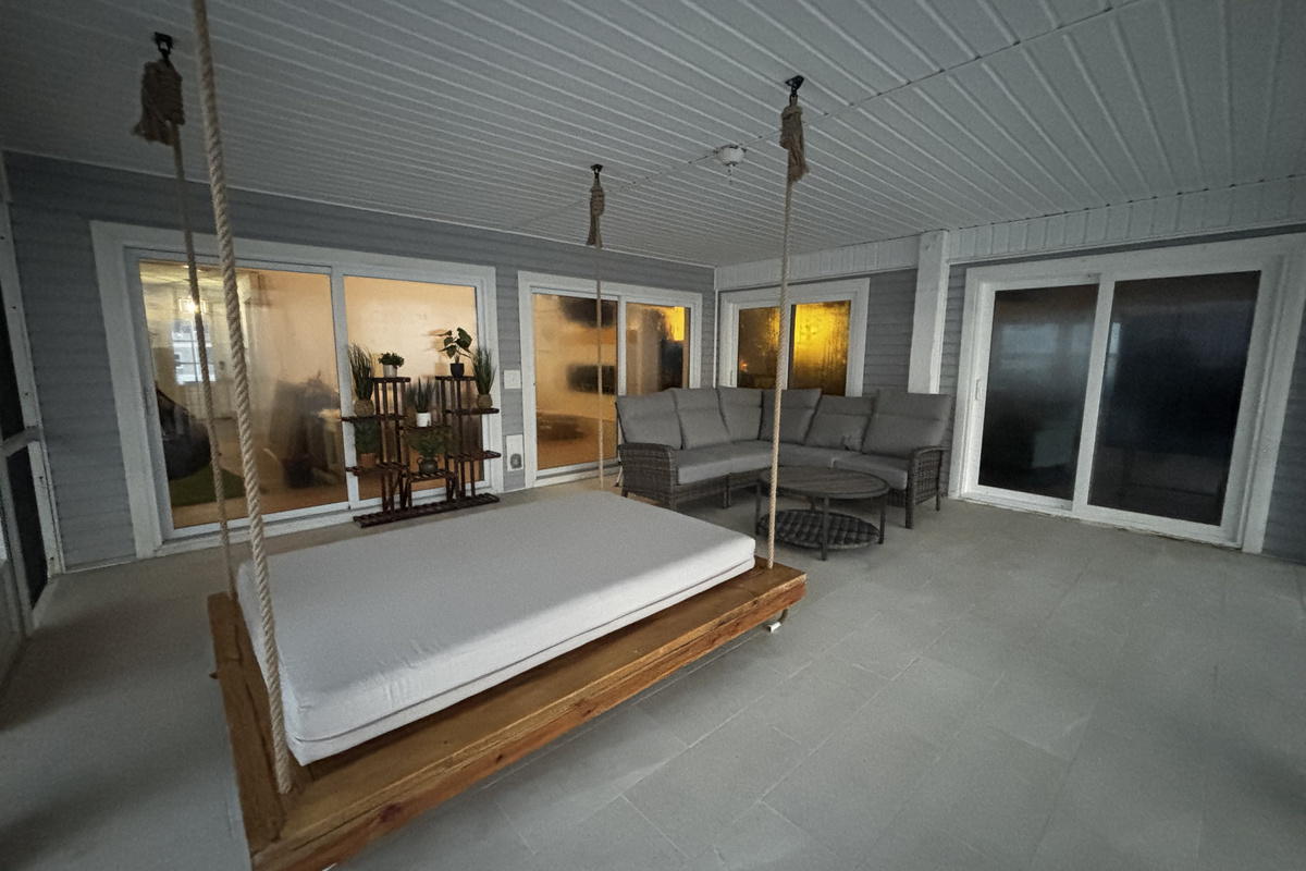 Screened porch area with swinging bed