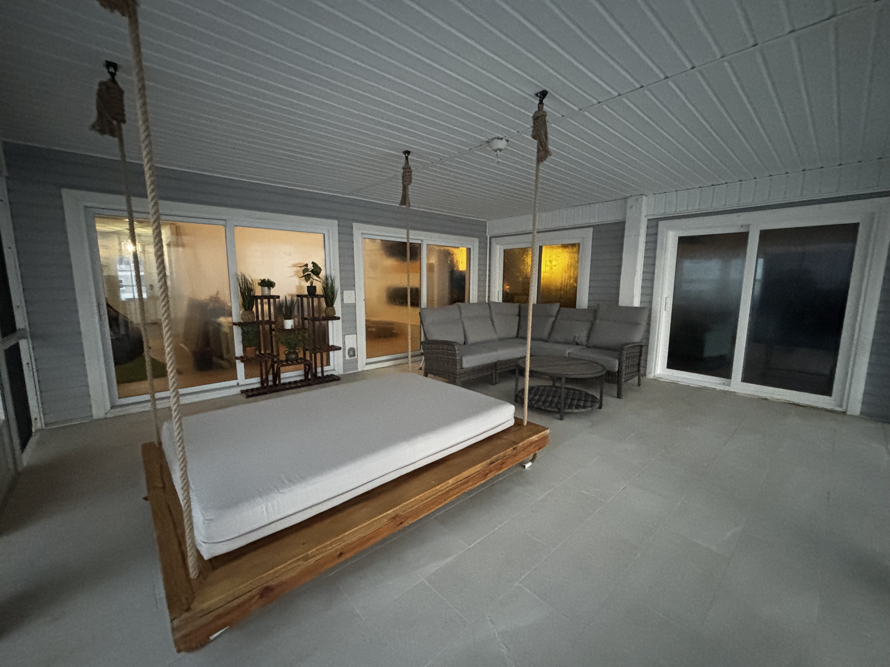 Screened porch area with swinging bed