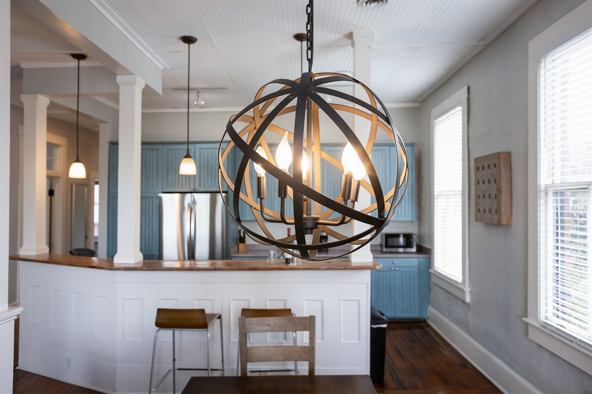 A modern light fixture adds a bold touch to this classic dining nook.