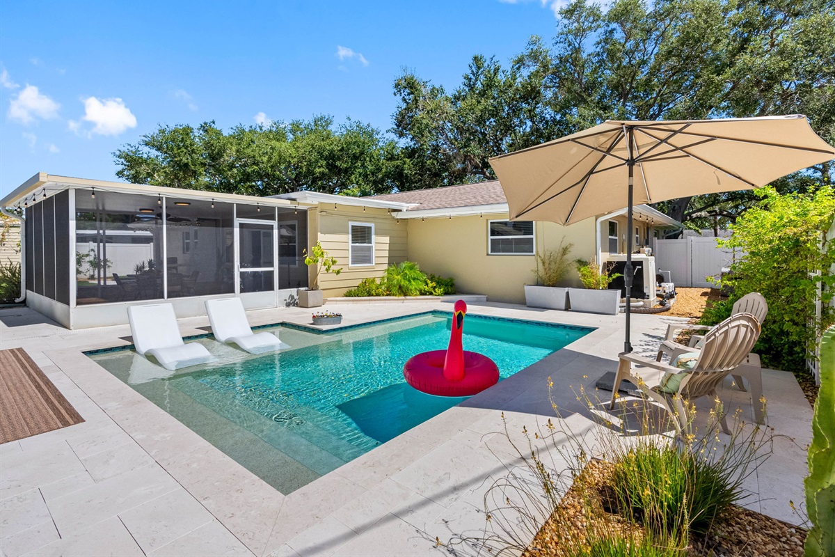 Dive into the turquoise waters of your heated pool, surrounded by privacy fencing and tropical plants.