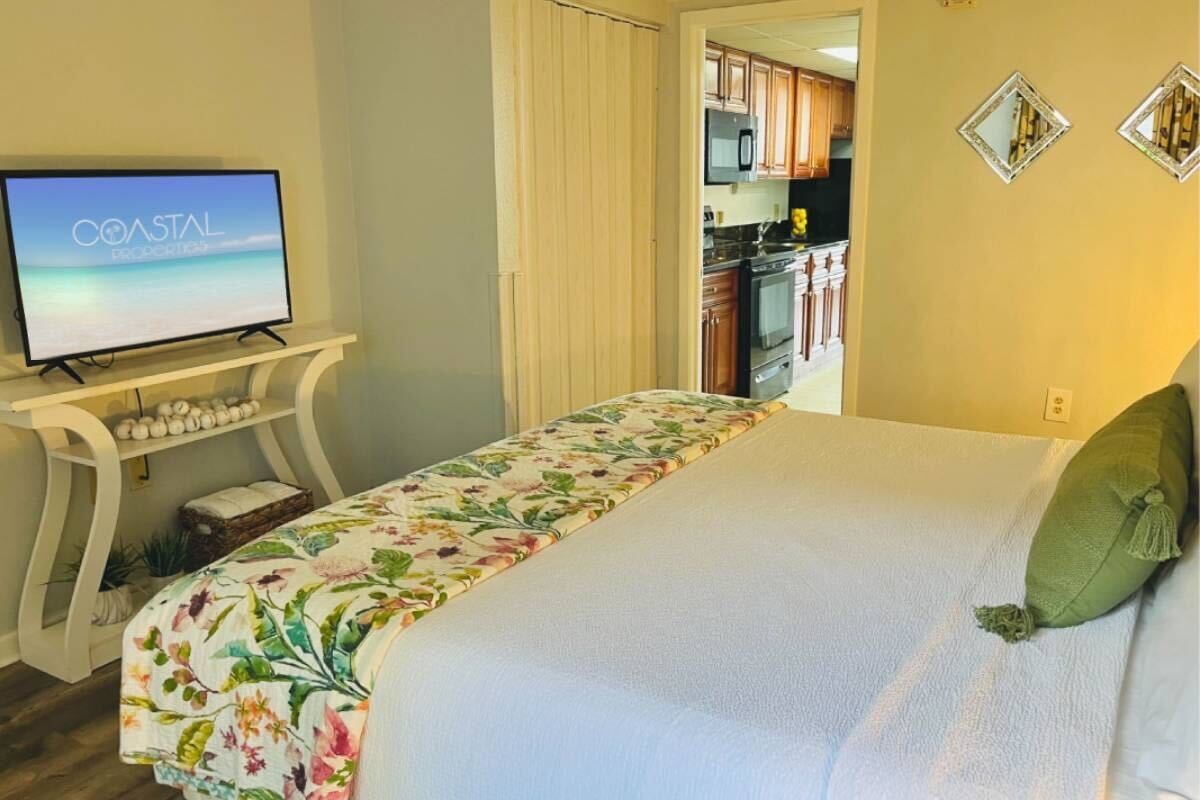 Relax in a spacious and elegantly decorated bedroom with plush bedding and soothing coastal tones.