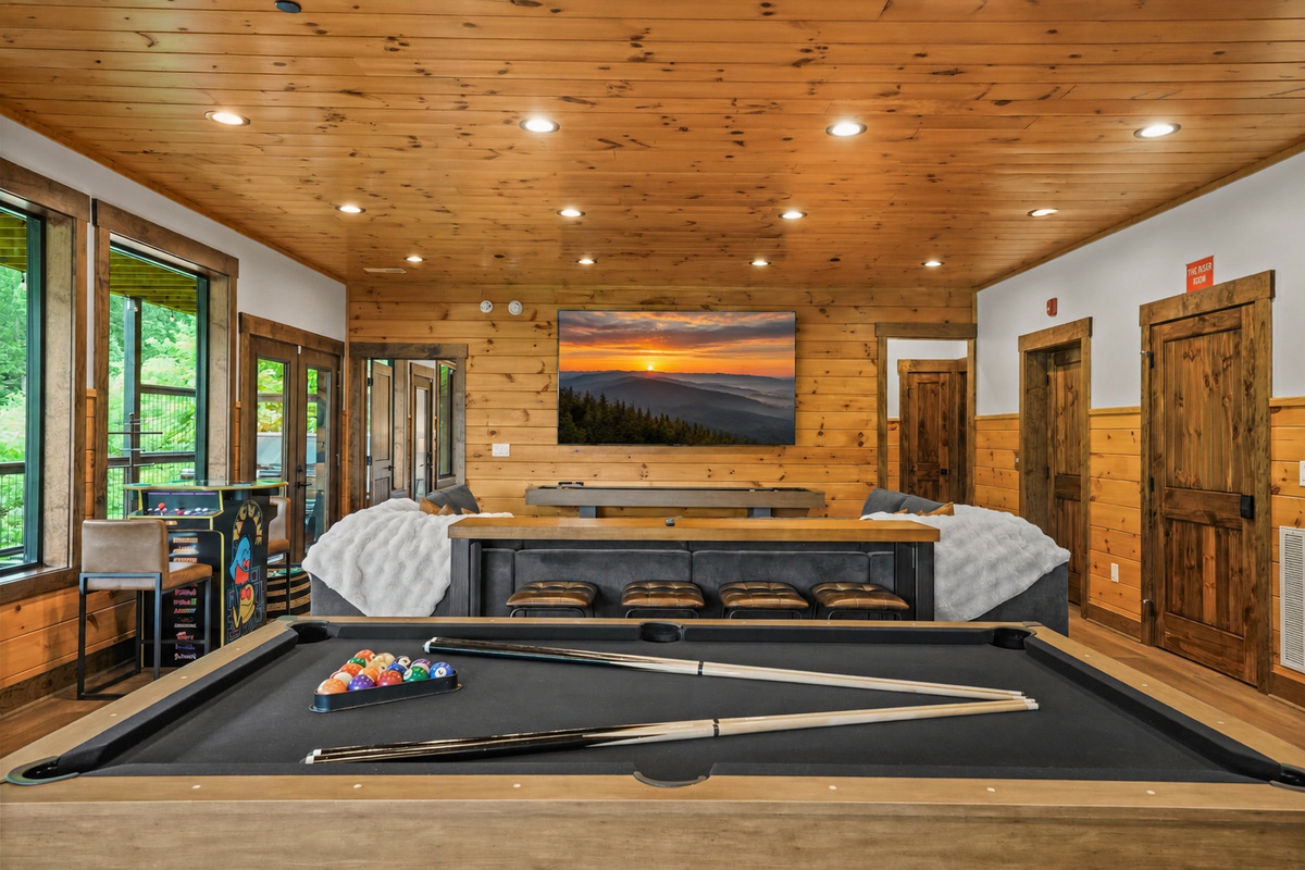 Perfect for game day, movie nights, or family fun, featuring a 100” TV, cozy sectional seating, and bar stools so everyone has a great view.