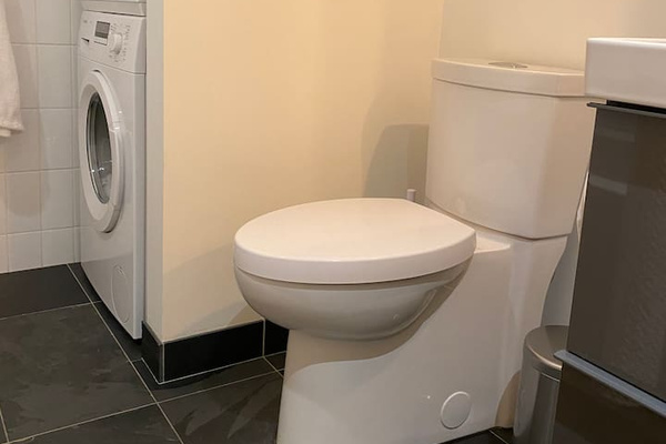 Bosch laundry machine and dryer in the corner beside toilette
The heated Slate tiles are 12”x24”