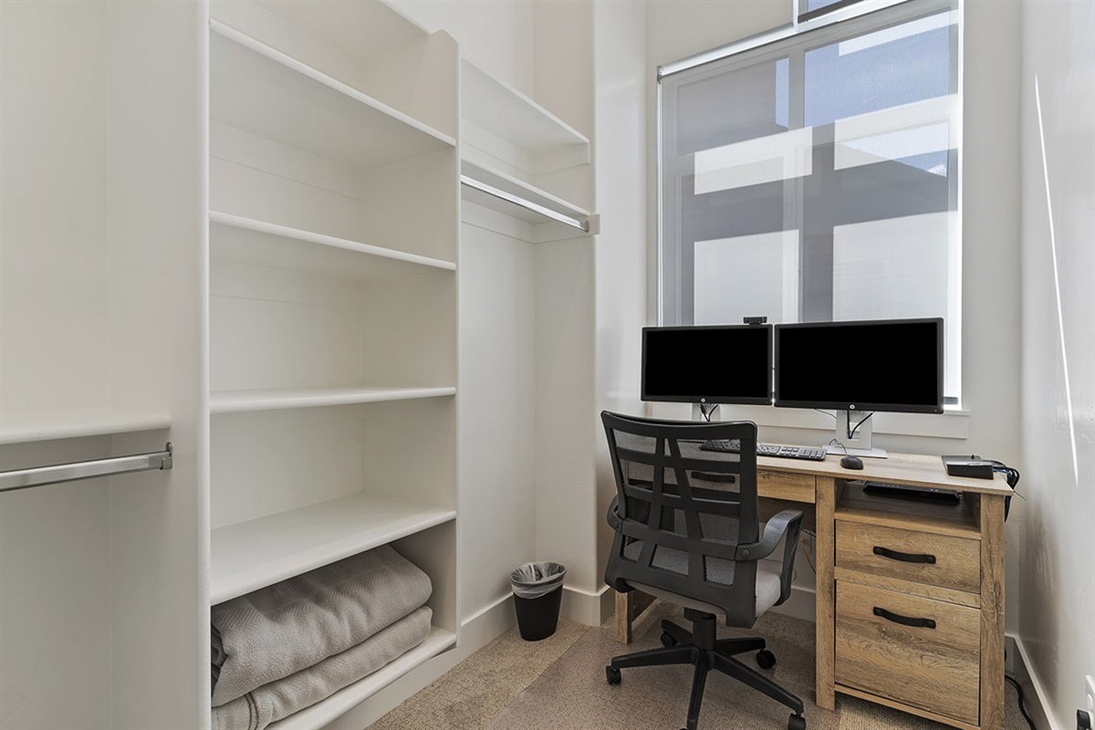 Enjoy the convenience of a spacious walk-in closet paired with a thoughtfully designed workspace, blending luxury with functionality.