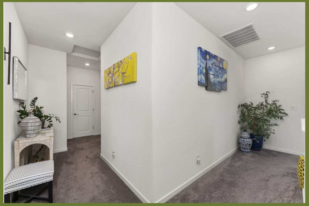 Upstairs hallway with soft carpeting, decorative wall art, and clean access between bedrooms and nearby rooms.