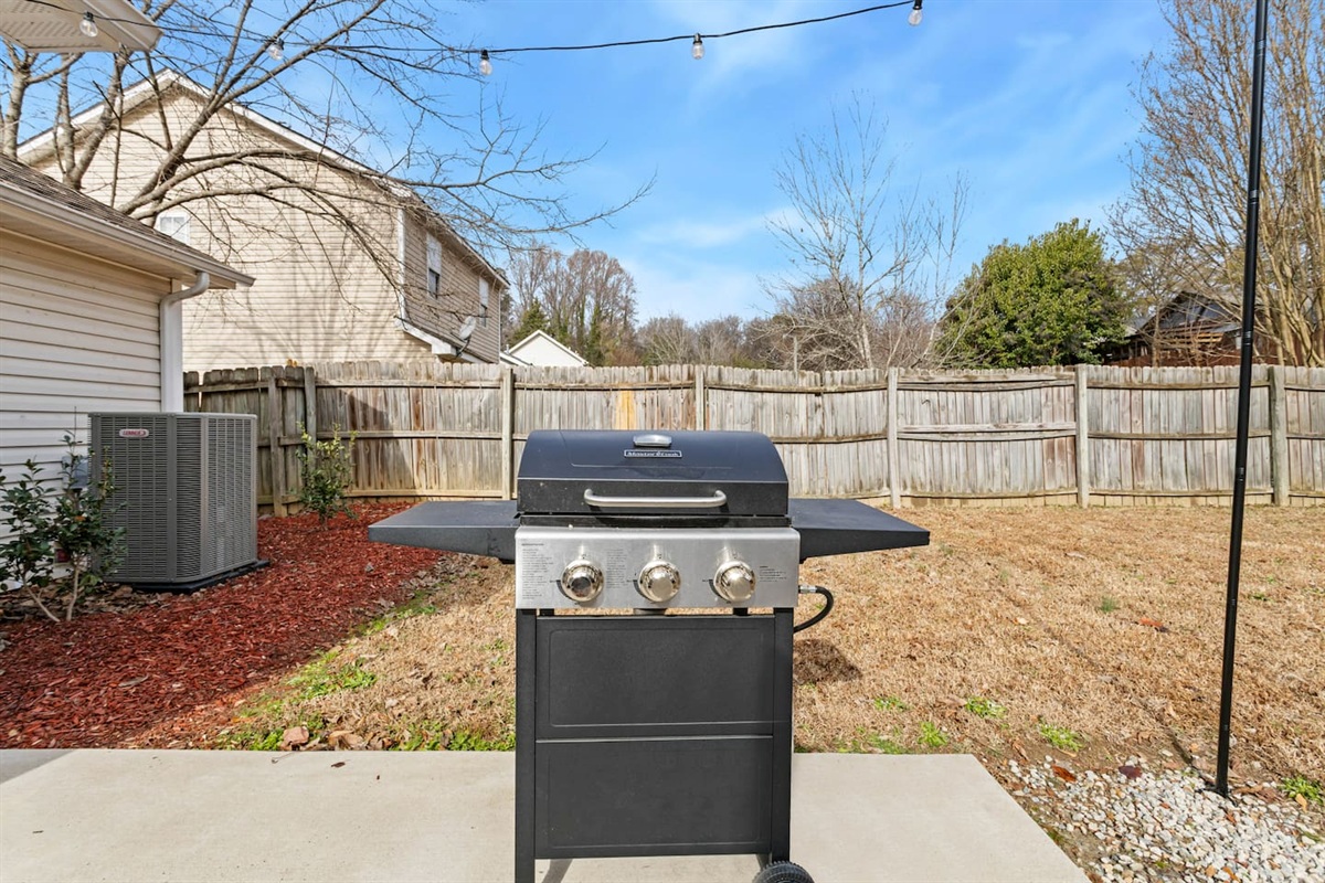 Private outdoor space with new fence, grill, and string lights for ambiance! 