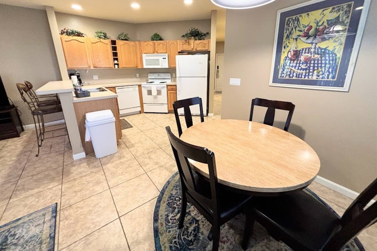Open dining and kitchen area featuring a round dining table, breakfast bar seating, and a fully equipped kitchen.