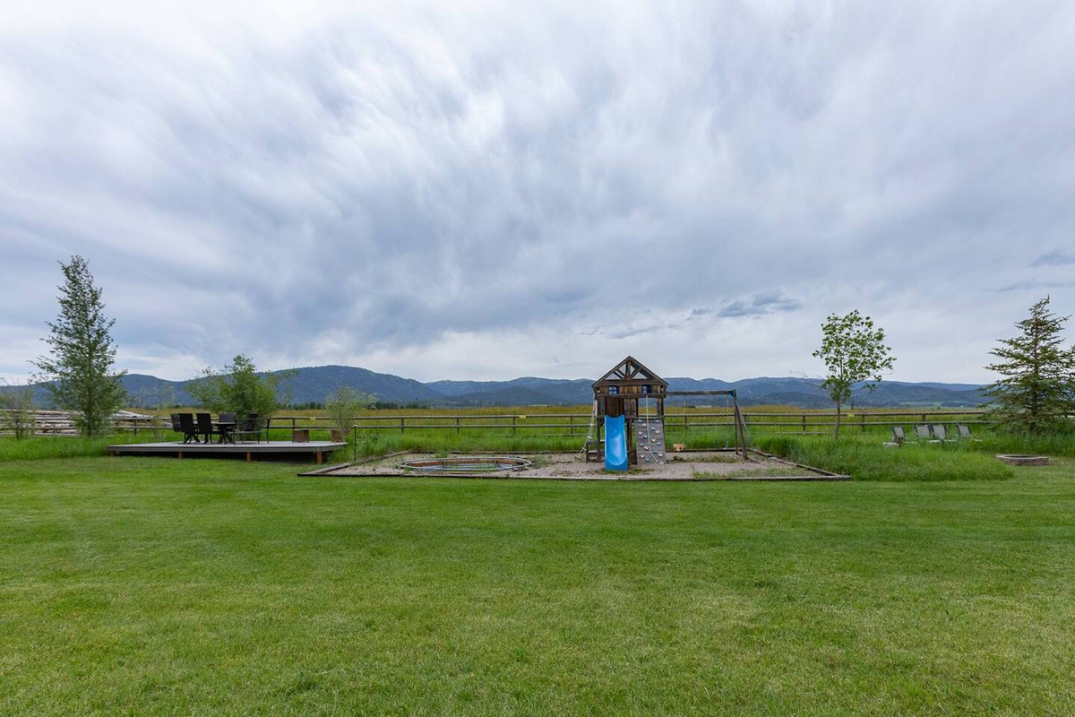 Backyard fun includes a playset and fire pit for evening gatherings