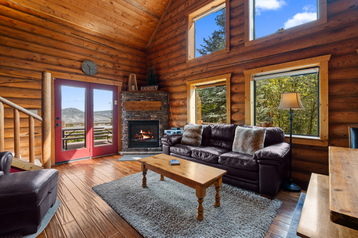 Warm main-level gathering space with comfortable seating and doors opening to the deck.