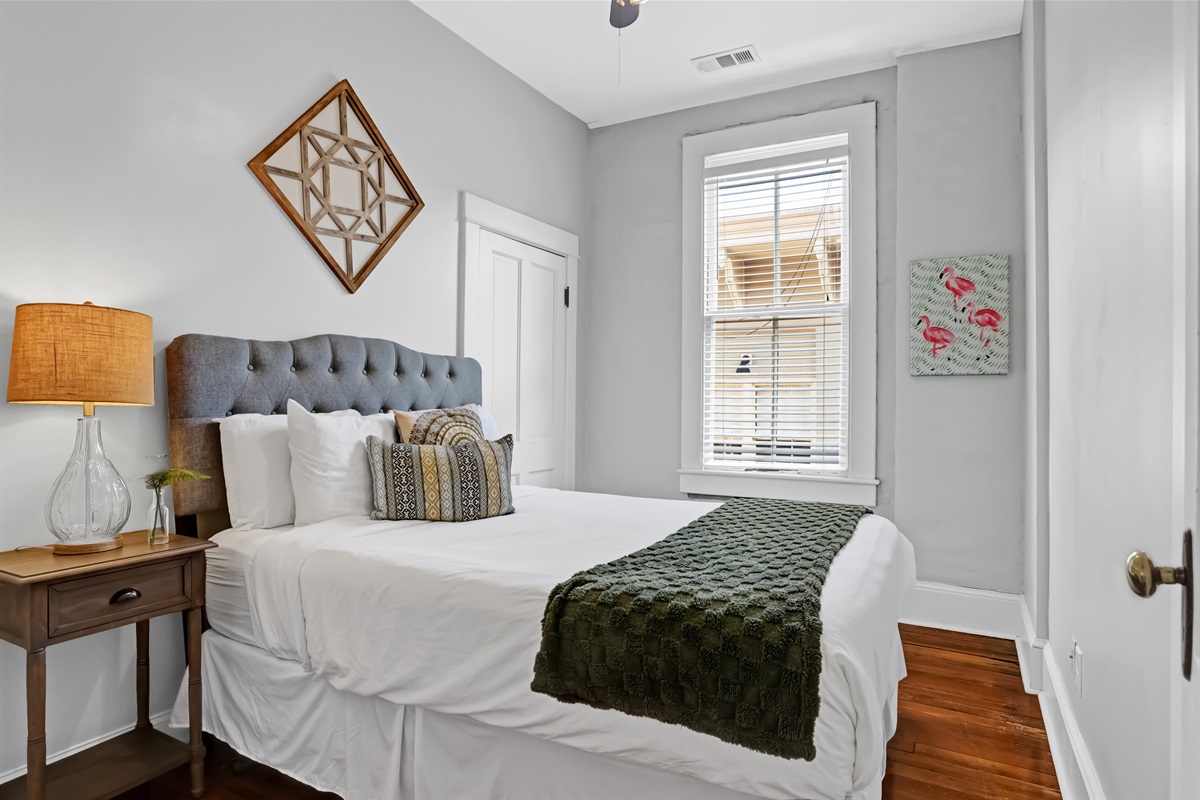 Cozy queen bed bathed in warm natural light for restful nights.