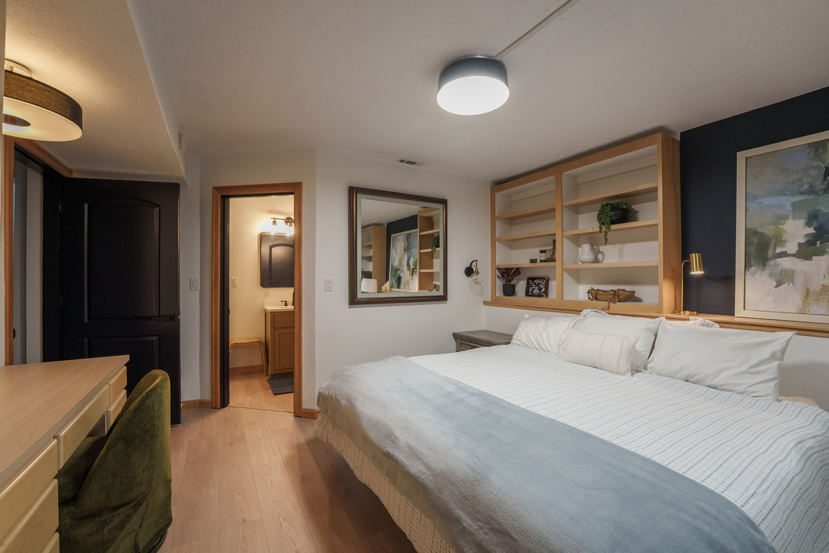 Bedroom 2 is thoughtfully designed for families and groups, featuring a queen bed, a queen-over-queen bunk bed, a dedicated remote-work desk, and a private ensuite bathroom (Bathroom 2)