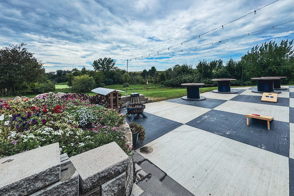Spacious patio with cornhole, string lights, and countryside views.