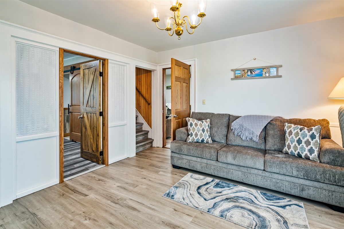Inviting living space with stylish barn door accents and updated flooring, blending rustic charm with contemporary comfort.