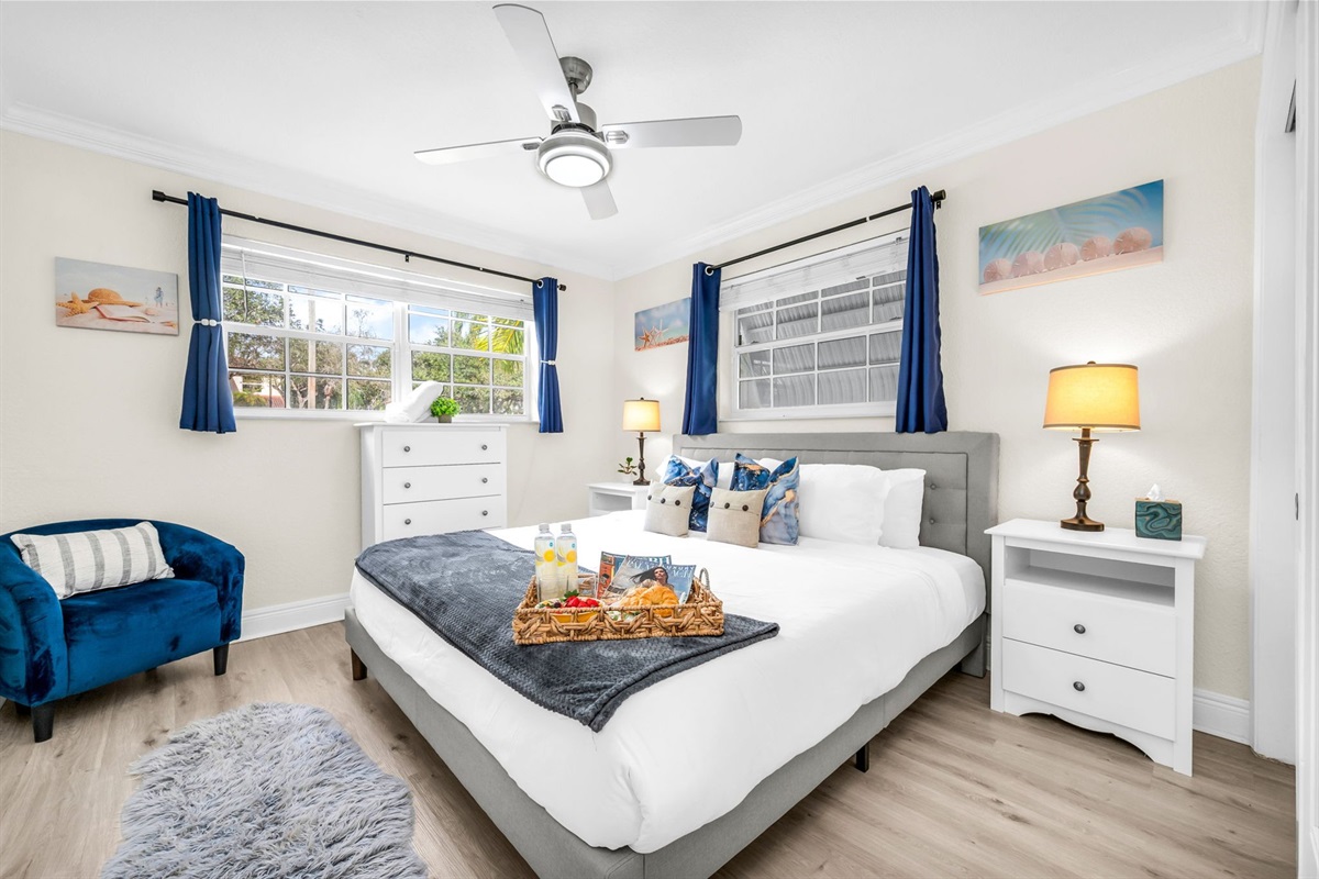 Unwind in the serene primary suite with a king bed, soft linens, and sunlit windows—your peaceful escape after a day at the beach.