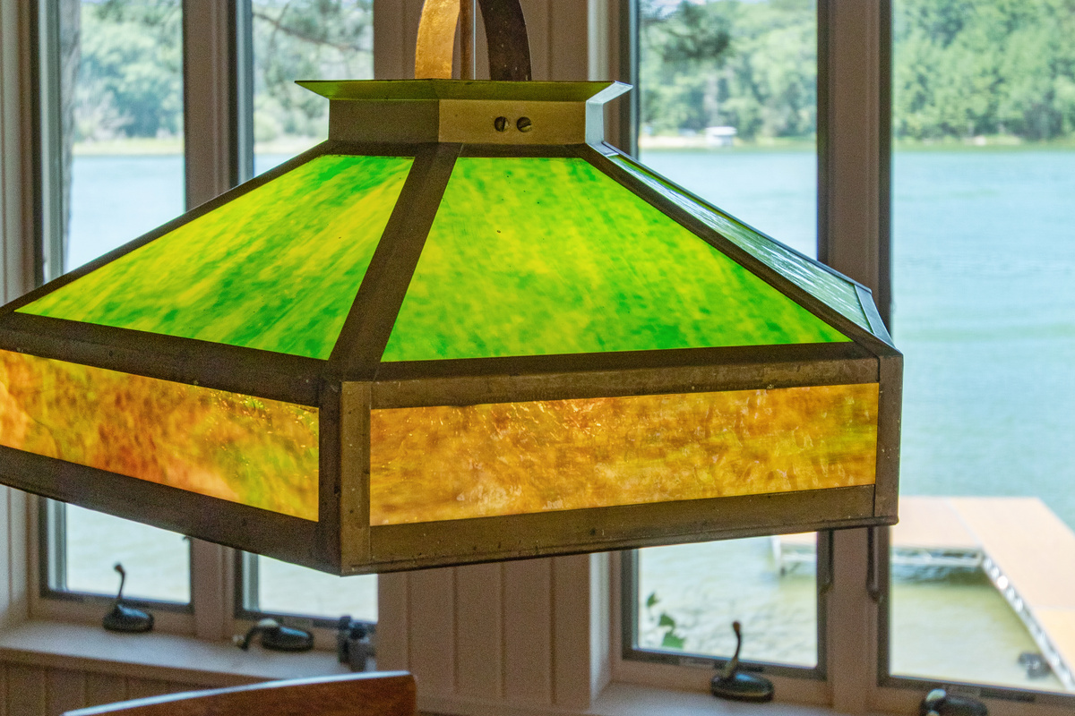 Beautiful cottage charm is in the details, like this one-of-a-kind light casting a warm glow over the table with the lake as your backdrop.