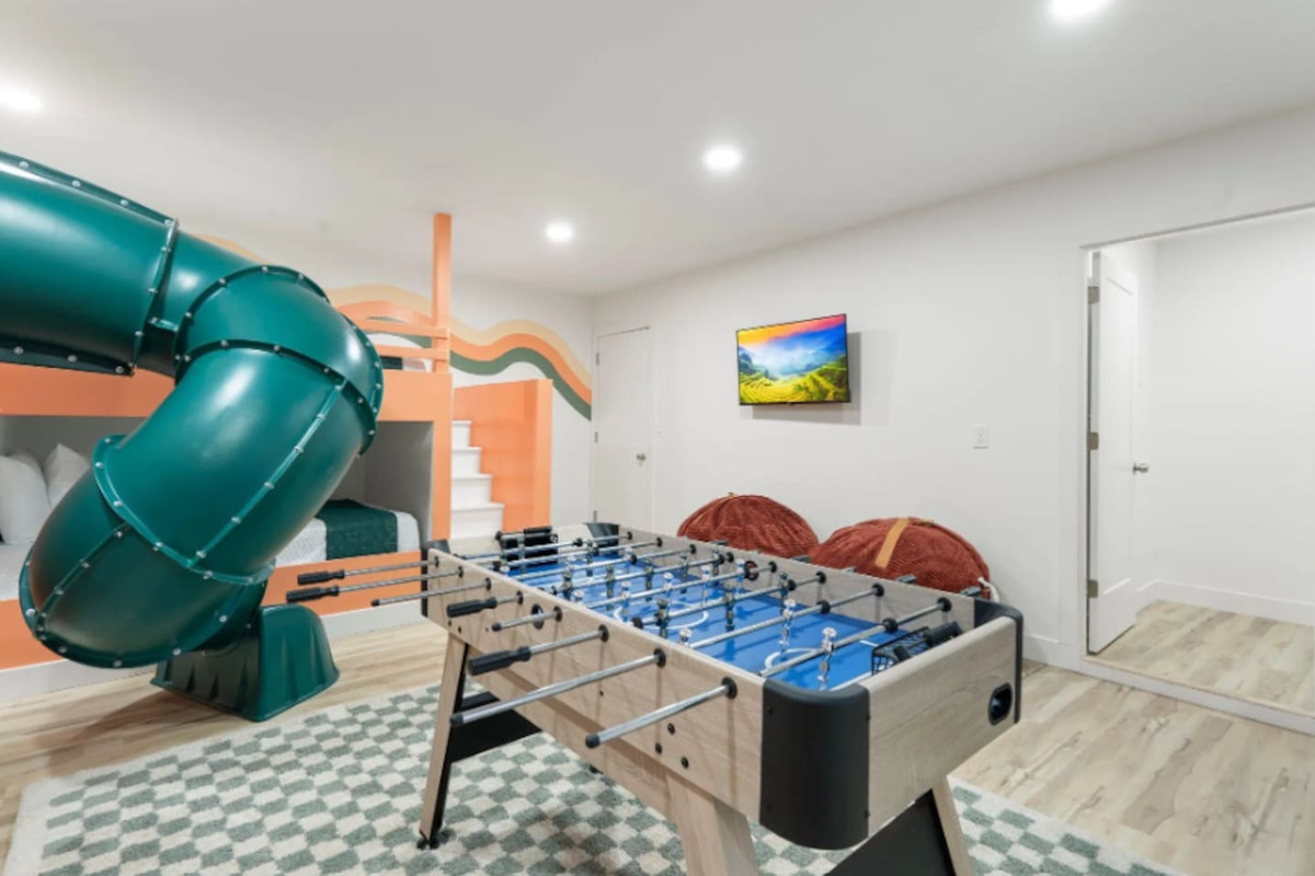 Another angle of the game room shows just how much is packed in here, from the slide to a mounted TV for background entertainment during game time.
