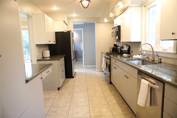 Kitchen from Dining Room showing pathway to dinette, fridge, stove, microwave, sink, dishwasher