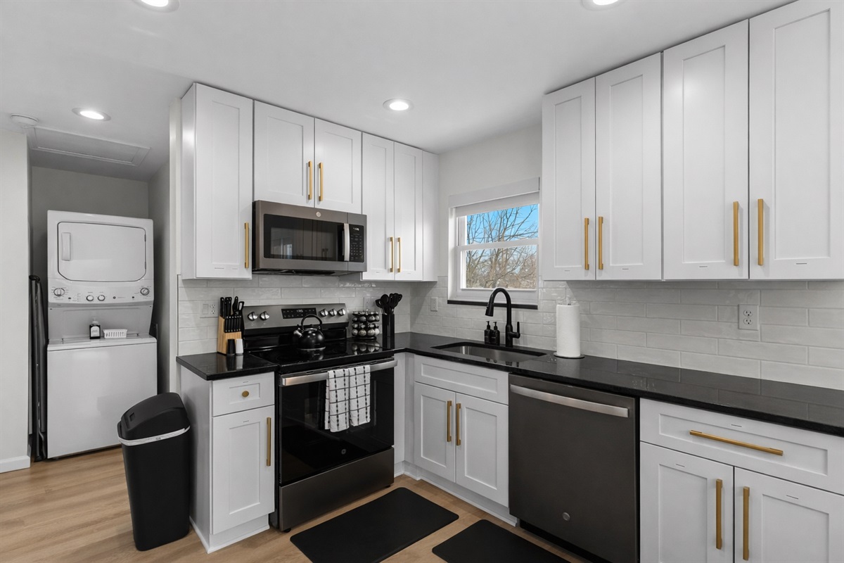 Fresh, stylish kitchen with white cabinetry, sleek black appliances, and plenty of counter space—bright, functional, and fully stocked for everyday cooking.