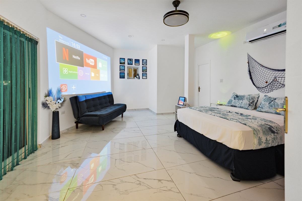 Projector screen and convertible sofa in the marine-themed bedroom