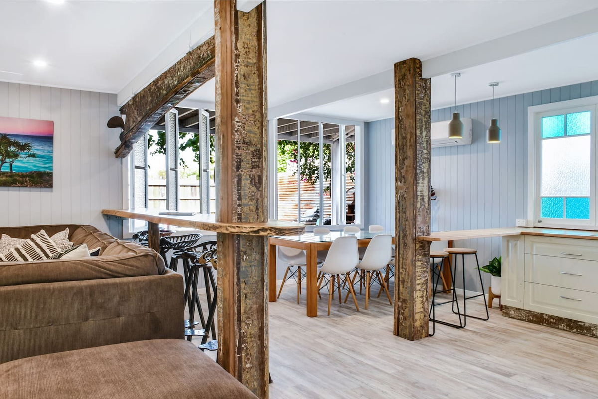 Reclaimed-style timber posts and beams give this open living area at Aaron's Beachside Boat House a distinctive, character-filled coastal feel.