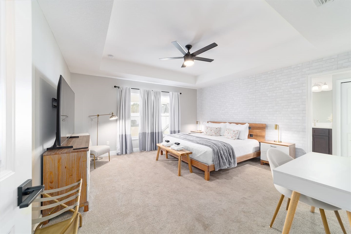 Relax in this bright and serene master suite featuring a plush king bed, cozy reading nook, Smart TV and a private bathroom. Soft tones, modern décor, and abundant natural light create the perfect space to unwind and recharge during your stay.