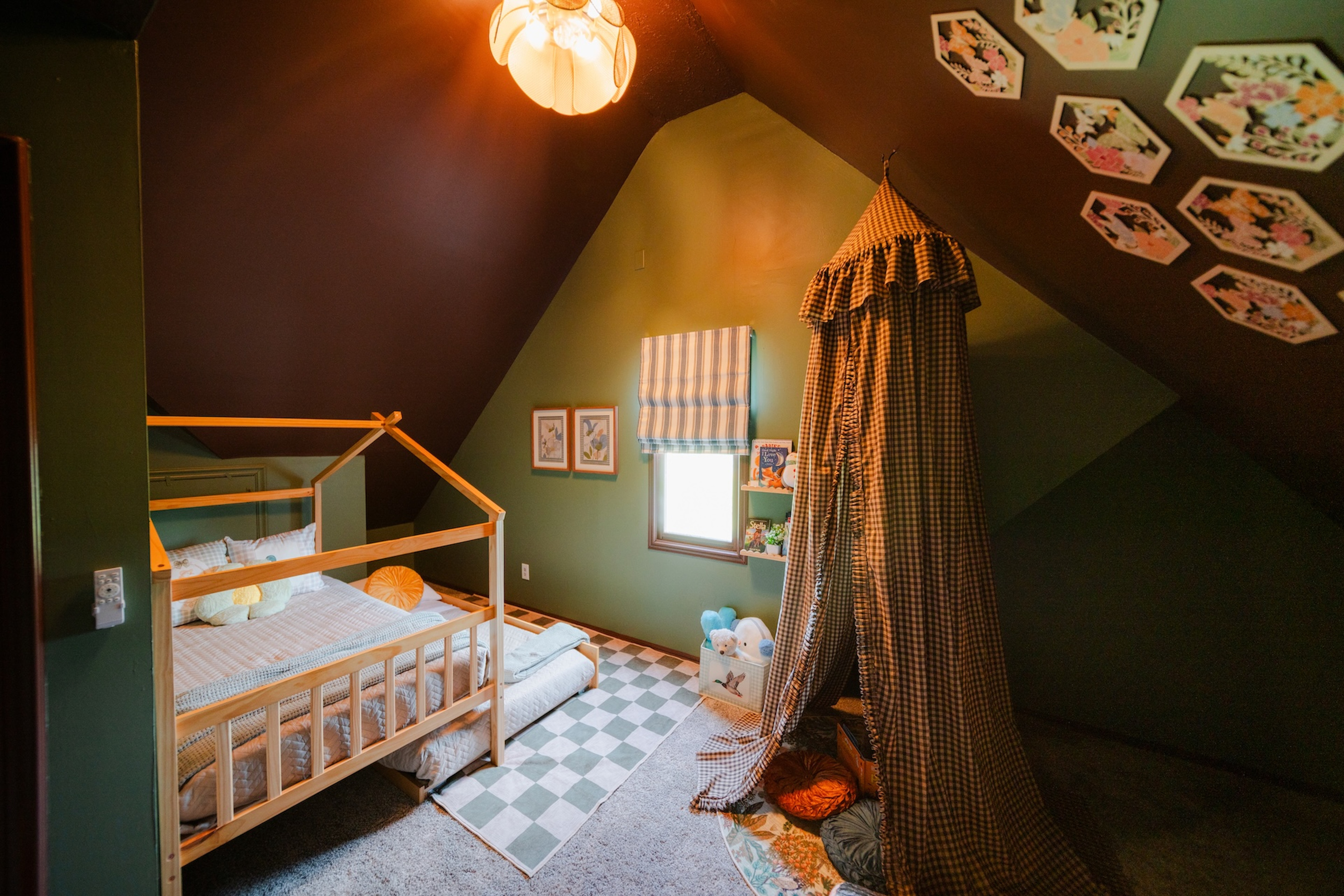 Connected kids' room with a twin bed, trundle, cozy canopy reading nook, and rock climbing wall.