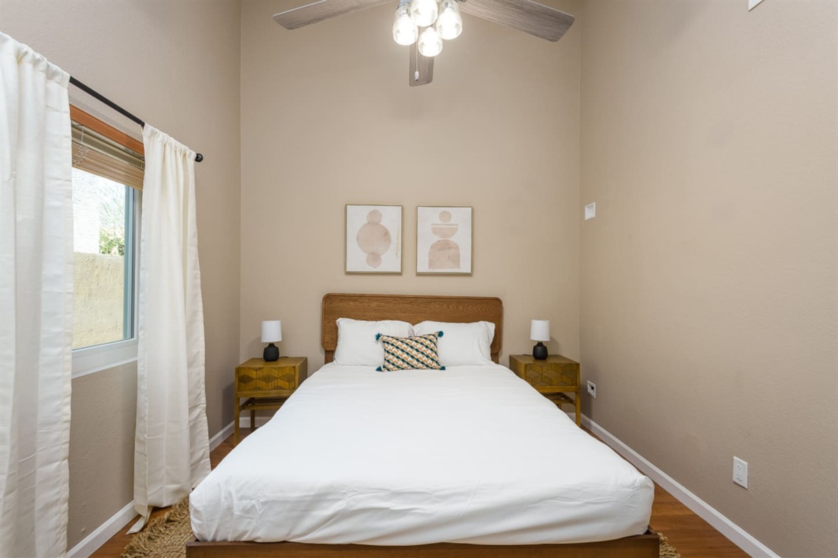 Guest Bedroom 2 with a queen bed, ceiling fan, bedside tables, and a calm setup for a comfortable stay.