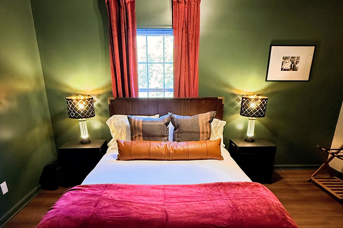 Rich green walls and amber lighting set the stage for restful nights and unhurried mornings — a cozy hideaway that feels both intimate and effortlessly stylish, echoing the quiet elegance of bourbon-country living.