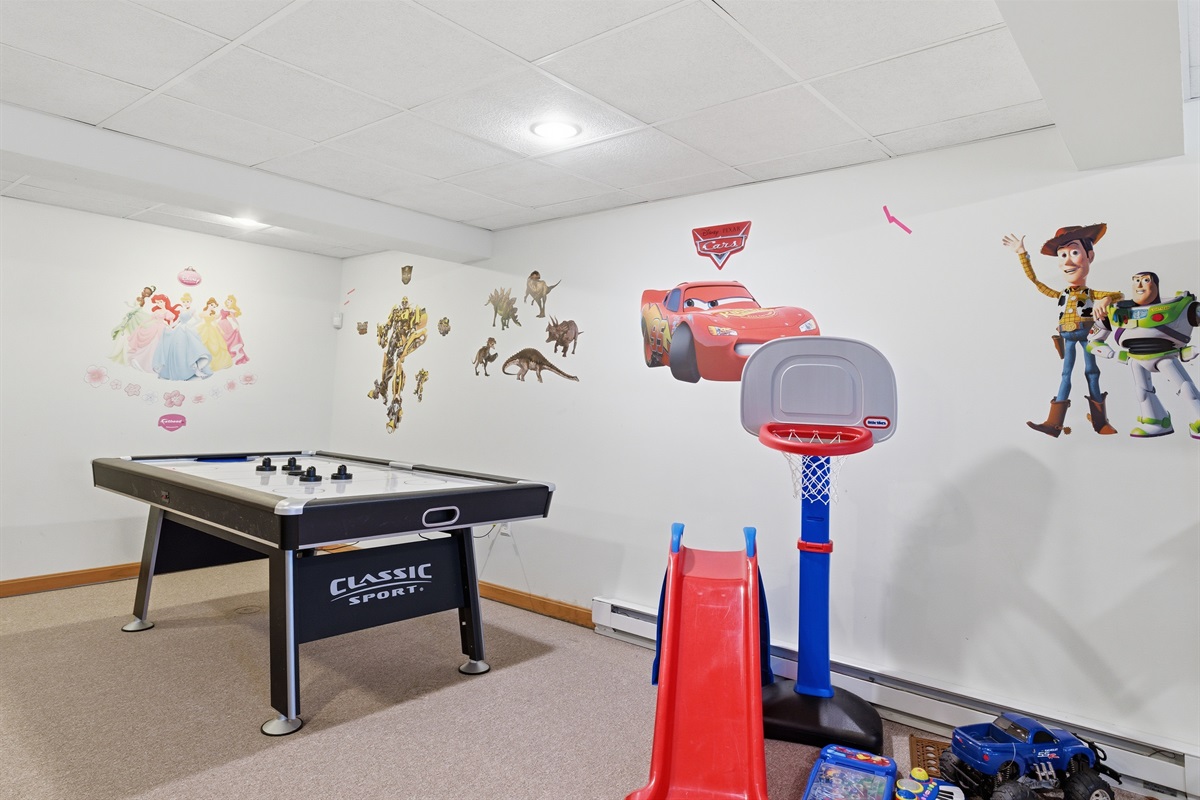 Playroom for kids and adults.  Air hockey, stereo system, toys, arcade, seating area.