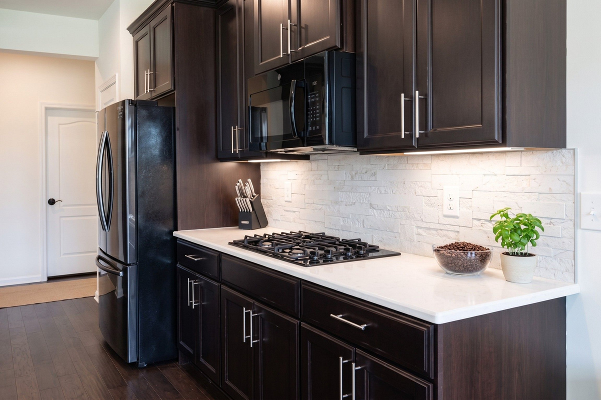 Fully appointed culinary workspace with gas range, double wall ovens, and ample cabinetry for long-term stays.