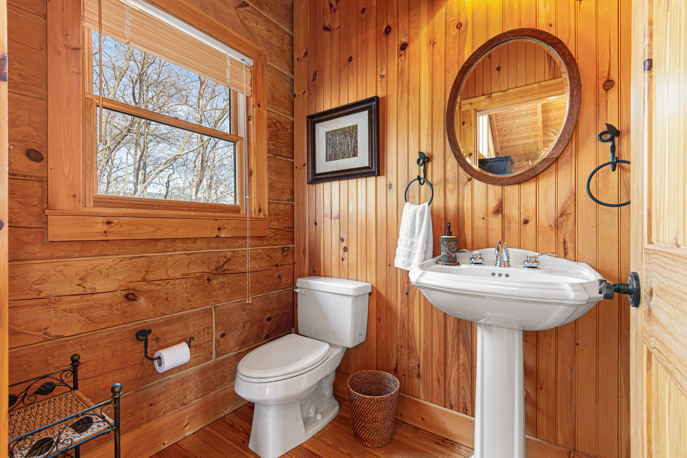 Half Bathroom: Experience rustic charm with elegant fixtures and serene forest views!