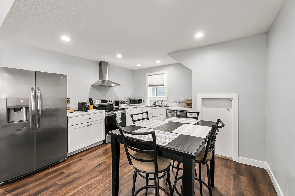 Bright dining area with a modern table for four, seamlessly connected to the fully equipped kitchen.