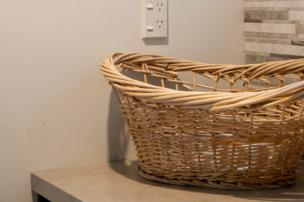 The laundry includes thoughtful details like a woven basket, wall art and tiled splashback, adding everyday ease to Fernhill Mountain Escape.