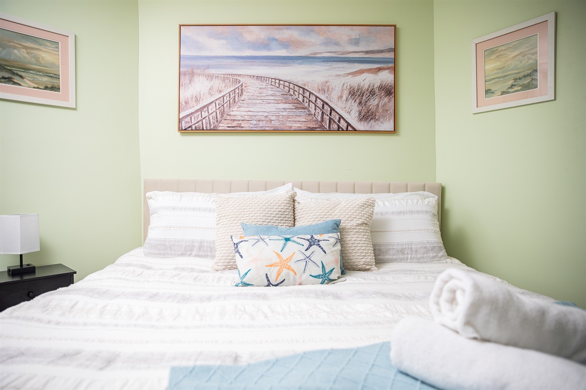Wind down in a serene queen bedroom where soft linens and cozy warmth set the tone for deep rest.