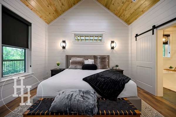 Master bedroom leading into the master bathroom. Smart TV, ceiling fan