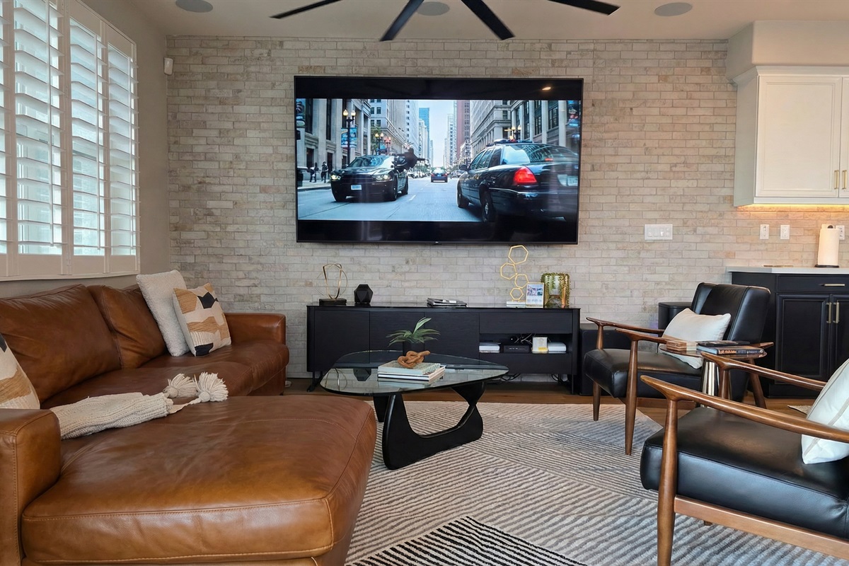 Plush Italian leather sofa & armchairs in the living room with an 87" HDTV.