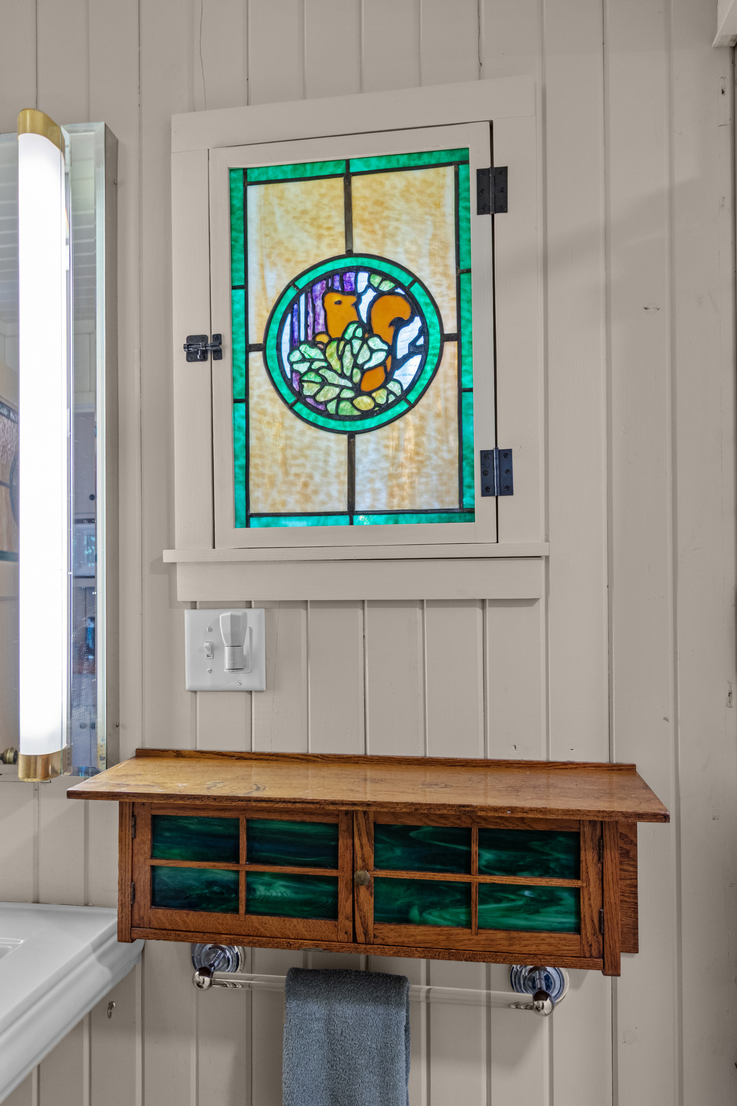 Charming cottage details are found throughout the home, including this beautiful handcrafted cabinet that adds warmth and character to the bathroom.