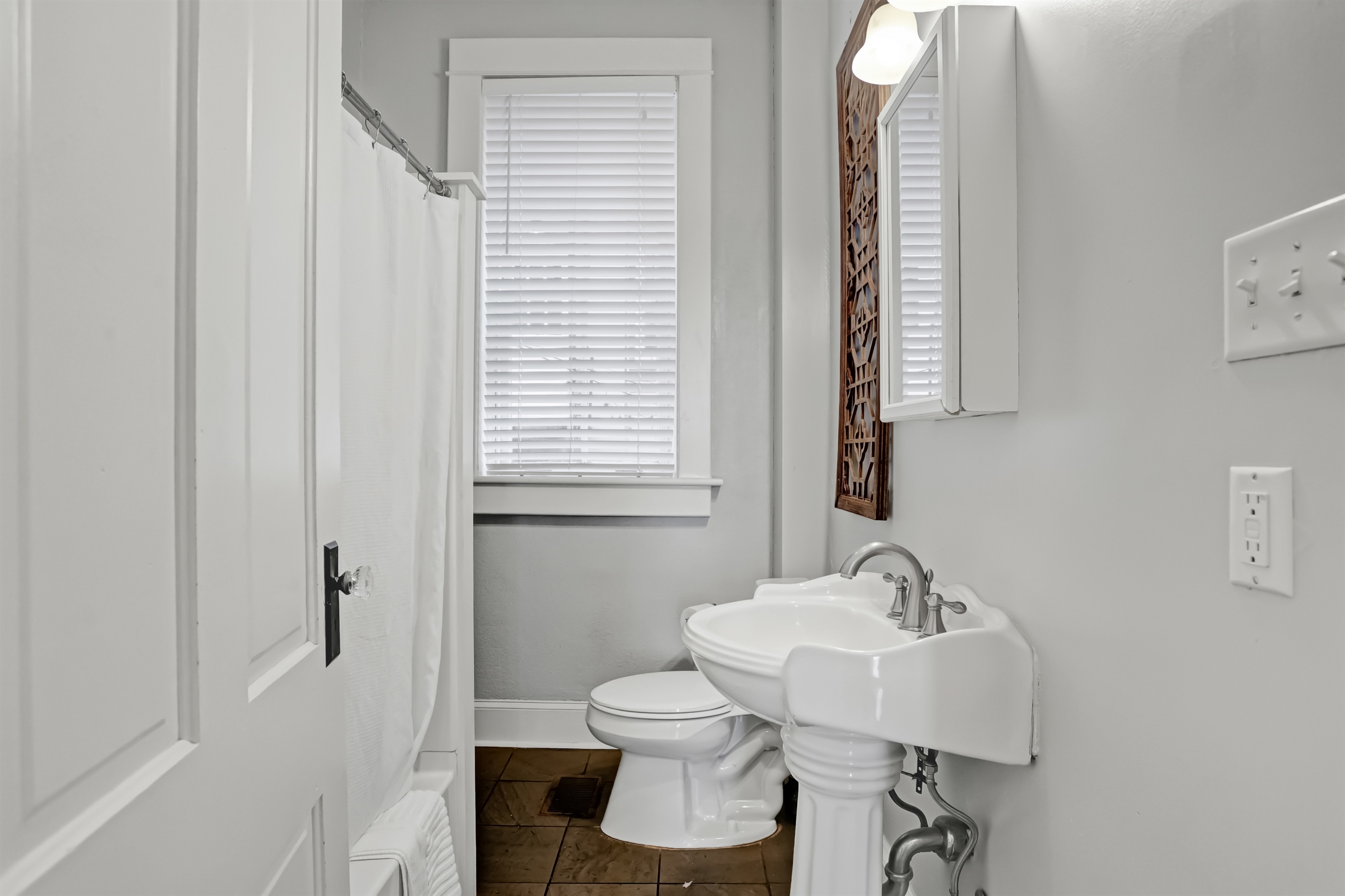 Classic full bath featuring a charming pedestal sink and clean design.
