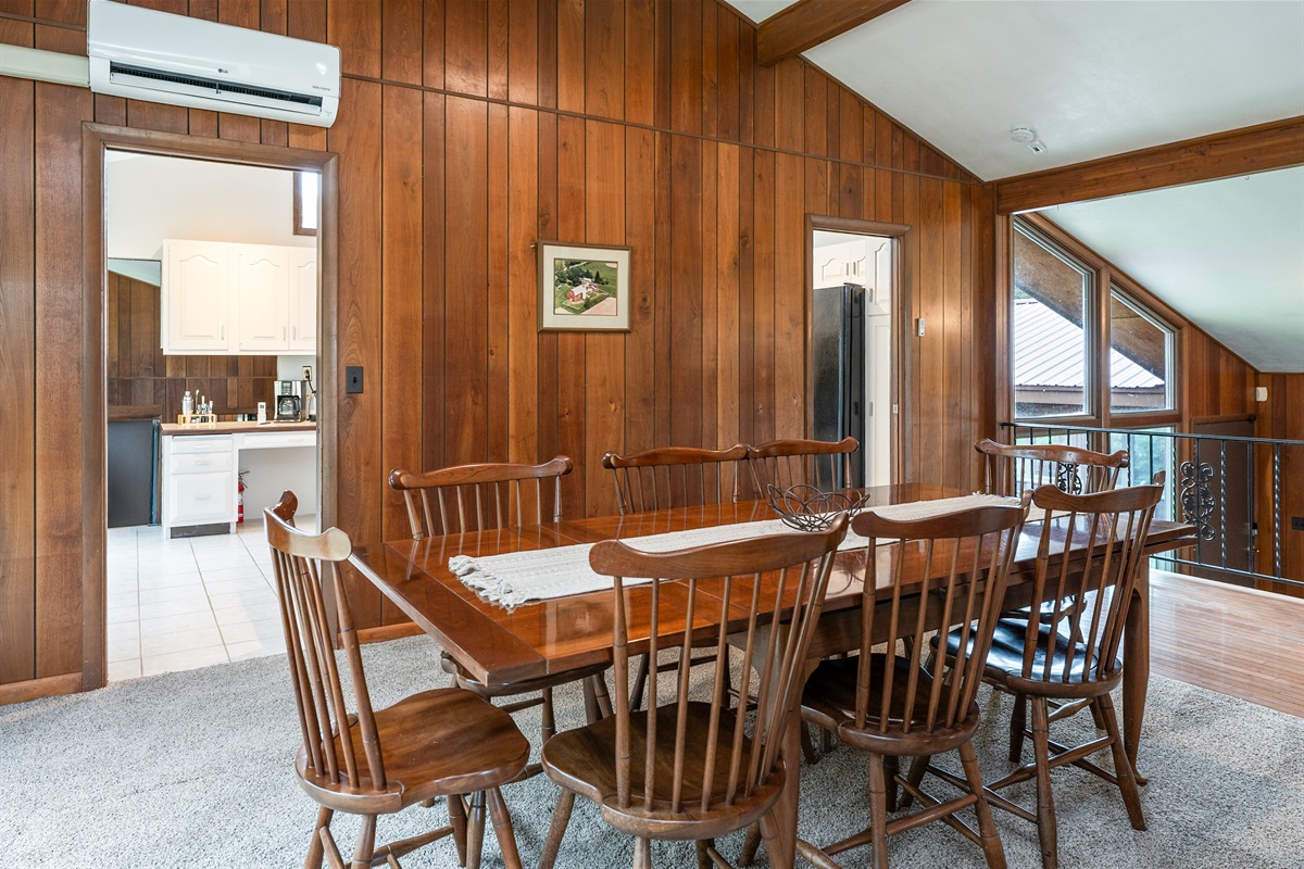 Enjoy cozy dinners by the stunning stone fireplace in this open-concept dining space, blending rustic charm with modern comfort.