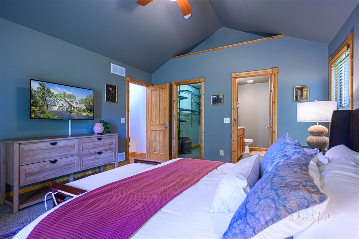 Primary bedroom on main floor includes king bed, walk in closet, Roku TV, and en suite bathroom