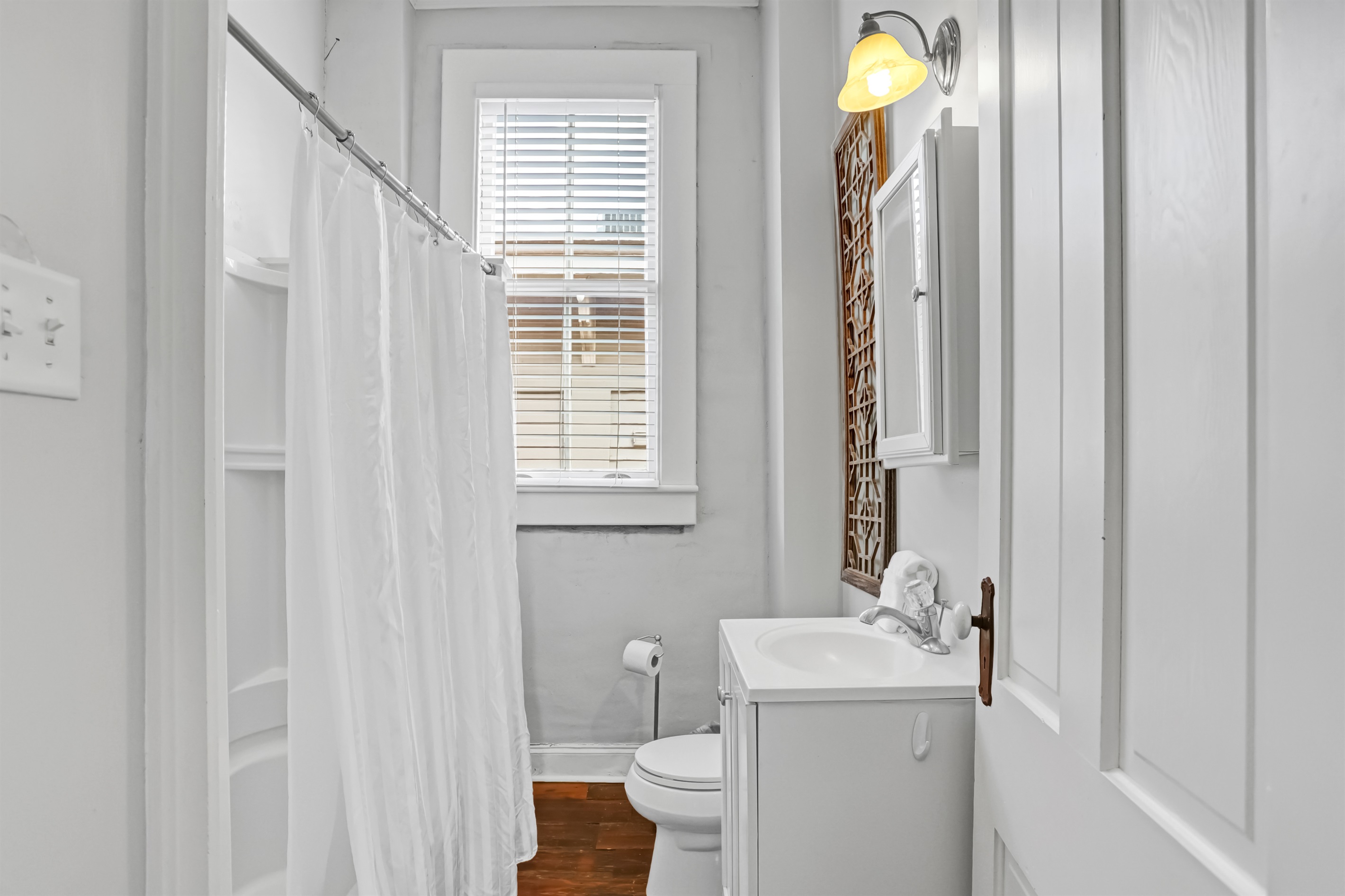 Full bath with a classic tub and a simple, charming vanity.