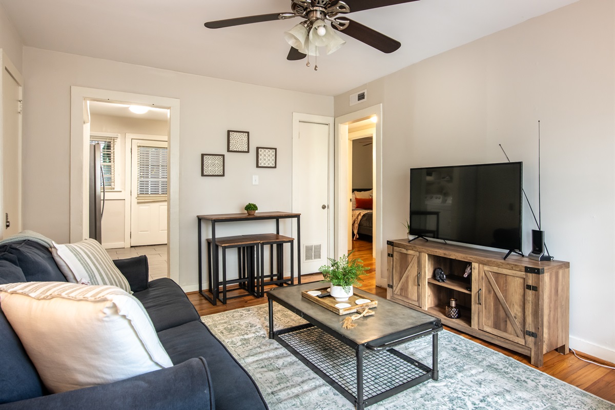 Dining and TV area with ceiling fan, natural lighting, and direct access to other rooms—both functional and homey.