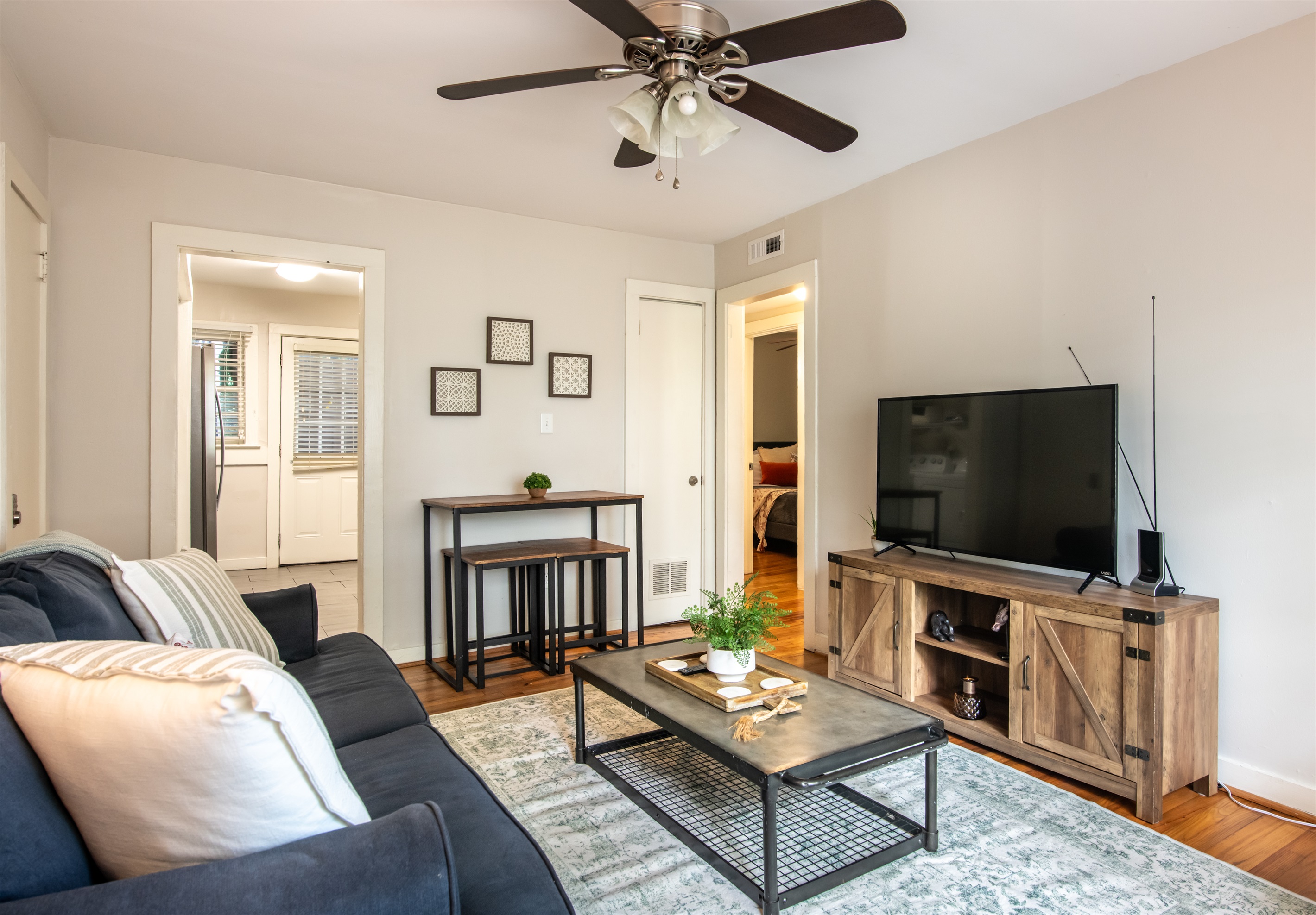 Dining and TV area with ceiling fan, natural lighting, and direct access to other rooms—both functional and homey.