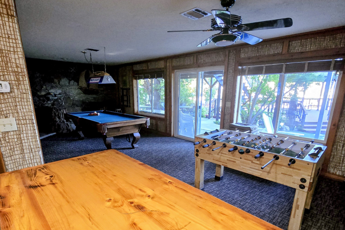 View from the mini bar to the pool table, foosball, and outside to the sitting area & BBQ