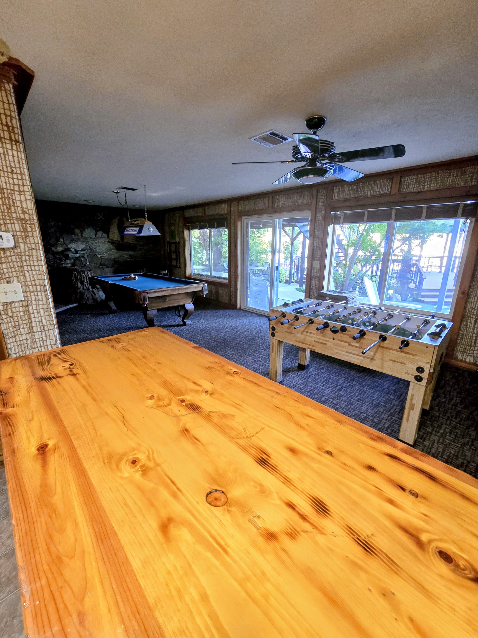 View from the mini bar to the pool table, foosball, and outside to the sitting area & BBQ