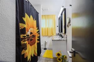 A sleek bathroom designed with striking black and yellow accents, offering a modern and vibrant aesthetic.