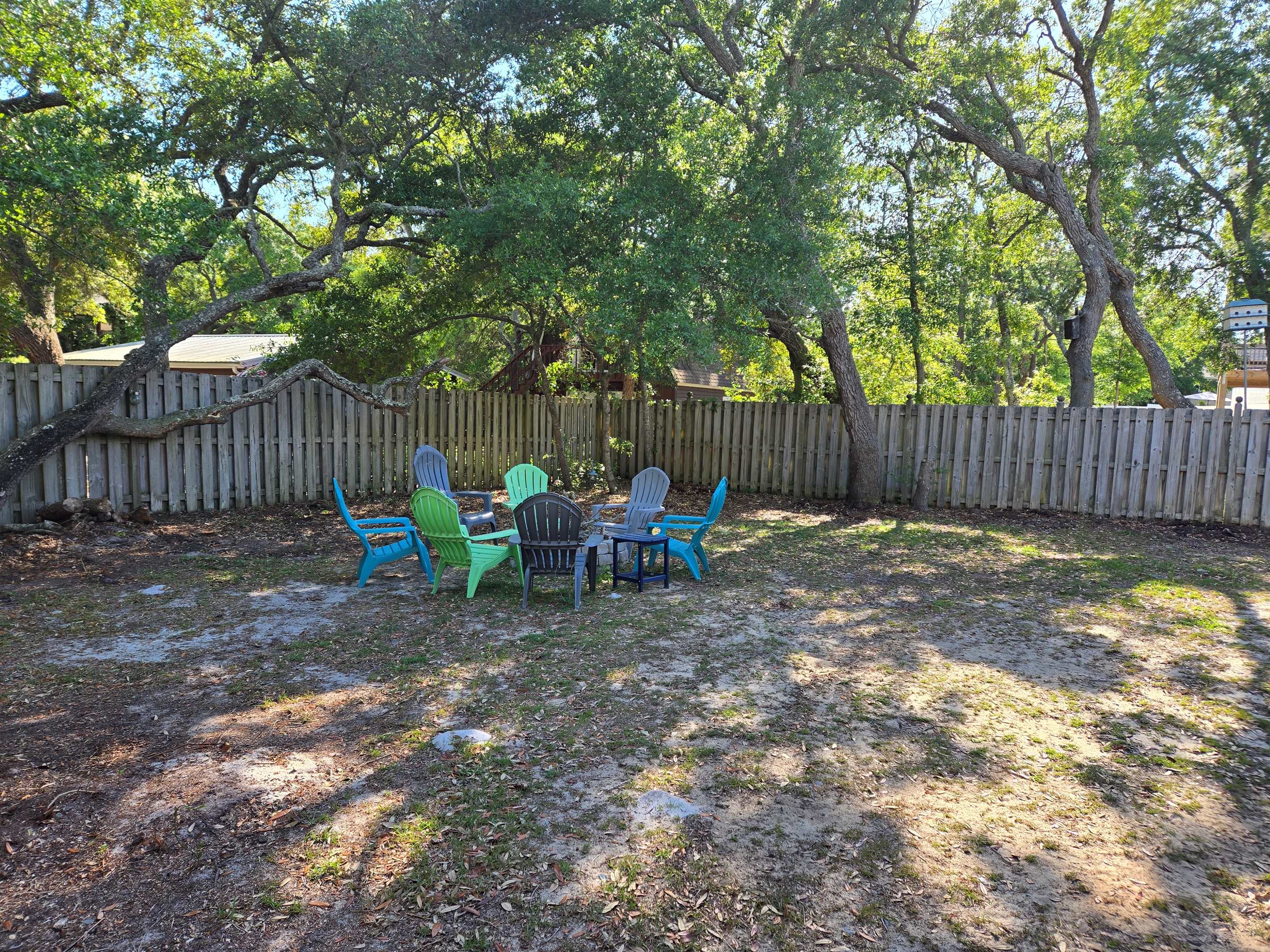 Large fenced in backyard with beautiful live oak trees
