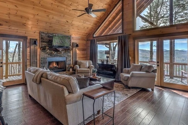Open concept living area with cozy seating, natural wood finishes, and expansive windows overlooking the Blue Ridge Mountains.